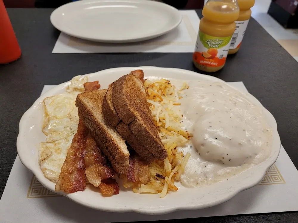 Eggs Bacon Hasbrowns and Biscuit Covered in Gravy with Butter